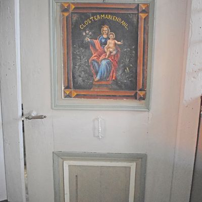 Die linke der beiden Türen neben dem Altar erinnert mit einem Maria-Jesus-Bild an das frühere Patronat des Helmstedter Klosters Mariental. Dieses Bild-Motiv ist nahezu identisch mit dem Relief, das sich an der westlichen Außenseite der Kirche befindet.