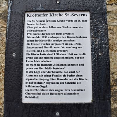 Auf dieser Tafel an der Südseite der Krottorfer Kirche Sankt Severus ist die Geschichte des Gotteshauses zusammengefasst.