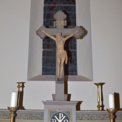 Der Altar der evangelischen Kirche Neuwegersleben mit dem gekreuzigten Jesus befindet sich  vor einem bunten Fenster, auf dem ebenso Jesus abgebildet ist.