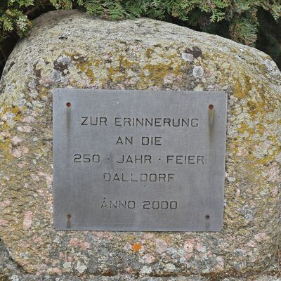 Mit diesem Stein wird neben der Kirche an das Jubilumsfest erinnert, das die Dalldorfer 250 Jahre nach der Wiederbesiedlung ihres Dorfes gefeiert haben.