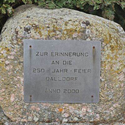 Mit diesem Stein wird neben der Kirche an das Jubiläumsfest erinnert, das die Dalldorfer 250 Jahre nach der Wiederbesiedlung ihres Dorfes gefeiert haben.