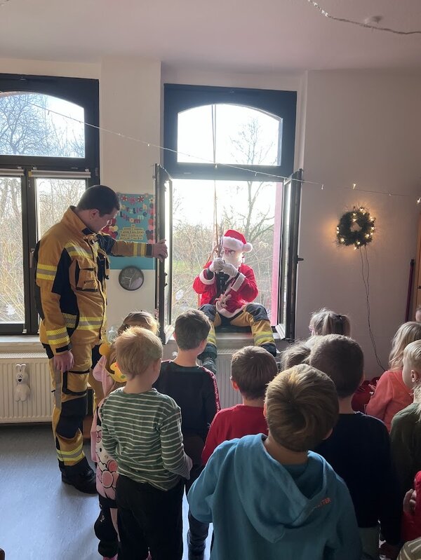 Spektakul&auml;rer Weihnachtsbesuch: Der Weihnachtsmann kommt durch das Fenster der Kita Bodespatzen