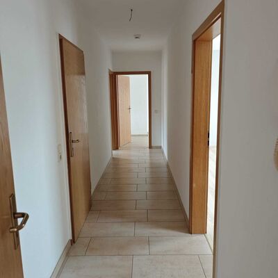 Der Flur verbindet die einzelnen R&auml;ume der Wohnung auf praktische Weise und unterstreicht den durchdachten Grundriss der 3-Raum-Wohnung in Kroppenstedt. Helle Wandfl&auml;chen und ein pflegeleichter Bodenbelag schaffen einen freundlichen ersten Eindruck. Die Wohnung liegt in ruhiger Lage in der Verbandsgemeinde Westliche B&ouml;rde.