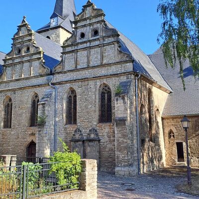 Au&szlig;enansicht der Martinikirche Kroppenstedt mit ihren charakteristischen drei Renaissancegiebeln an der S&uuml;dseite. Durch die Erweiterung des Kirchenbaus zwischen 1593 und 1616 erhielt die Kirche ihre ungew&ouml;hnliche vierschiffige und unsymmetrische Gestalt. Im Hintergrund erhebt sich der historische Kirchturm, dessen Urspr&uuml;nge bis in die romanische Zeit zur&uuml;ckreichen.