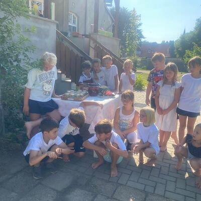 Sommerferien 2026 im Hort &raquo;Villa Einstein&laquo; in Ausleben: Die Kinder kommen im Freien an einem Tisch mit sommerlichen Erfrischungen zusammen - ein gemeinsamer Moment aus einer erlebnisreichen Ferienzeit.