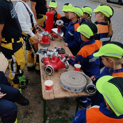 Die Kinderfeuerwehr Ausleben steht an der Station der Feuerwehr Ausleben. Auf einem Tisch wurden mehrere verschiedene Feuerwehrger&auml;te verteilt. Die Teilnehmer mussten anschlie&szlig;end das Gewicht der einzelnen Feuerwehrger&auml;te sch&auml;tzen.